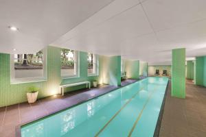 阿德莱德阿德莱德财政大楼阿迪那公寓酒店的一座拥有绿色墙壁的大型游泳池