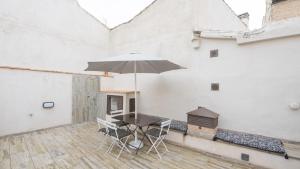 托莱多Apartamentos Virgen Blanca的庭院配有桌椅和遮阳伞。