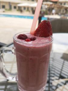 杰里科巴巴尔沙姆度假酒店的装满粉红色饮料的玻璃杯,带草莓