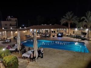 杰里科巴巴尔沙姆度假酒店的一群人晚上站在游泳池旁