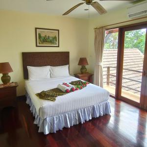 芭东海滩Baiyok Villa seaview and edge pool的卧室配有一张白色大床,拥有圣诞装饰