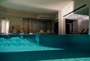 奥特朗托Basiliani - CDSHotels的一座带椅子的建筑内的游泳池
