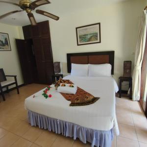 芭东海滩Baiyok Villa seaview and edge pool的卧室配有一张白色大床,床上有毯子