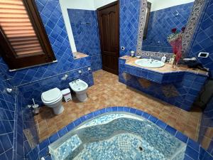兰佩杜萨Villa Dalila的蓝色瓷砖浴室设有水槽和卫生间