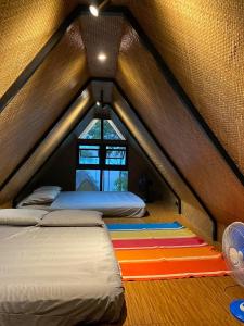 CavintiLake Of The Woods PH Entire Island Exclusive Glamping的一间设有两张床的房间和一个位于帐篷内的窗户