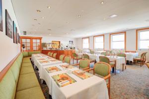 阿尔滕堡阿斯特酒店的一间设有白色桌椅的用餐室