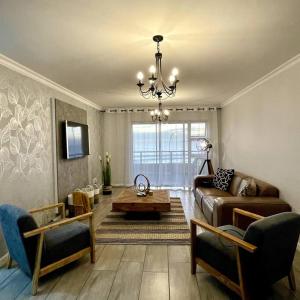 布鲁堡史特兰Luxurious 2-bedroom beach apartment with a view!的客厅配有沙发和桌子