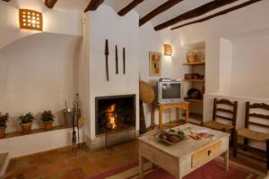 布利亚斯Casa rural Plaza Vieja en Bullas的客厅设有壁炉和桌子