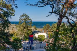 特拉森海德Scheunenbäckerei Usedom, Ostseebad Trassenheide的背景为海洋的游乐场