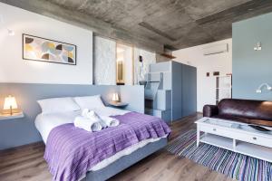 加亚新城Bridge It - Suites & Views的一间卧室配有一张带紫色毯子的大床