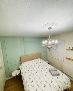 KentEntire Home between London and Kent- Mulberry House的一间卧室配有一张床和一个吊灯