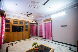蓬蒂切里Sri Balaji Villas的客厅配有电视和桌子