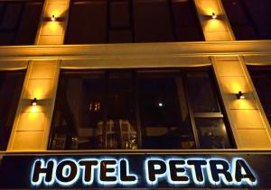 图兹拉PETRA HOTEL TUZLA的夜间在大楼前的旅馆标志