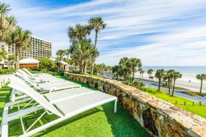 加尔维斯敦Gulf Overlook San Luis Resort 1035的一张白色的躺椅,俯瞰着海滩