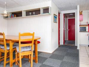 Nørre Lyngvig6 person holiday home in Hvide Sande的一间带桌椅和红色门的用餐室