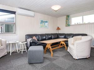 Nørre Lyngvig6 person holiday home in Hvide Sande的客厅配有黑色真皮沙发和桌子