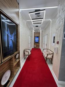阿斯塔纳E-lite& Meatador的走廊上设有红地毯、椅子和电视