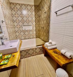 坎波斯杜若尔当Villa Vintage Campos - Piscina e opções de suites com hidromassagem的一间带水槽、浴缸和长凳的浴室