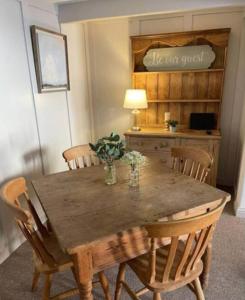 金斯林Grade II Listed 2 Bed Cottage with Free Parking的一张带椅子的木桌和一张带台灯的桌子