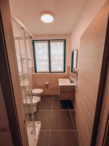 布奇纳斯科Blu Hotel的浴室设有2个卫生间、水槽和淋浴。