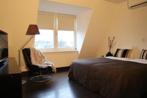 SteenbergenBar-Bistro-Hotel DOK的卧室配有床、椅子和窗户。