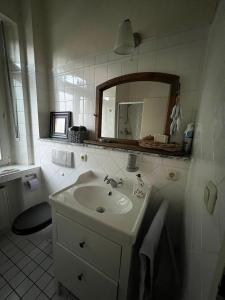 格雷文布罗赫Im alten Pastorat的白色的浴室设有水槽和镜子