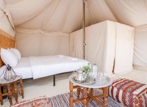 El KariaLes Terrasses d'Agafay的帐篷内一间卧室,配有一张床