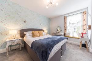 格拉斯米尔Heidi's Grasmere Lodge的一间卧室设有一张大床和一个窗户。