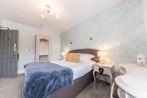 格拉斯米尔Heidi's Grasmere Lodge的一间卧室配有一张带蓝色毯子的床