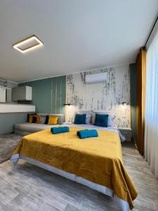 皮亚特拉-尼亚姆茨AAB Studio Central的一间卧室配有一张带蓝色枕头的大型黄色床