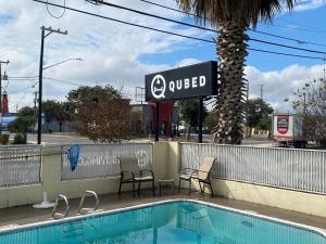 圣安东尼奥Qubed San Antonio的一个带两把椅子和标志的游泳池