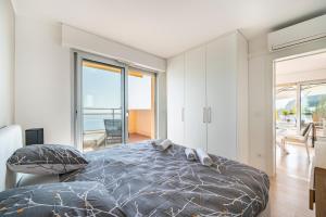 罗克布吕讷-卡普马丹Baie Roquebrune, Vue Mer, Parking Gratuit - AJ的一间卧室设有一张床,享有海景