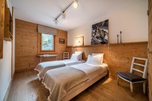 里雾诗Apartment Valvisons Les Houches Chamonix - by EMERALD STAY的木墙客房的两张床