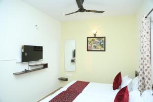 班加罗尔Bangalore Airport Inn Hotel, Near Kempegowda Airport的一间卧室配有一张床和一台平面电视