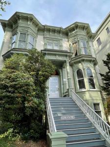 波特兰Northwest Portland Hostel的一座大房子,设有通往前门的楼梯