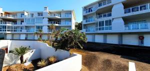 拉姆斯盖特Breathtaking 3 Bedroom unit with amazing sea views的一座大型公寓楼,前面有棕榈树