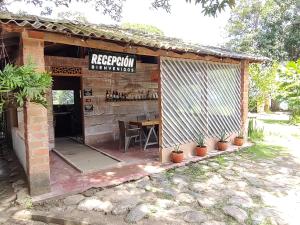 米卡Finca Hostal Bolivar - Casa Quinta的一座带桌子和标志的建筑