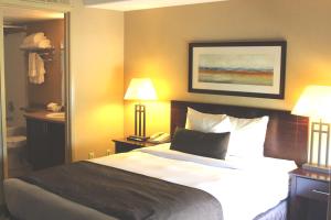 麦克默里堡富兰克林套房酒店 的一张位于酒店客房内的床铺,配有两盏灯和一部电话