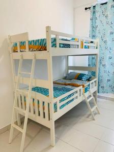 边佳兰Brand New Cozy home Desaru Pengerang near Sebana Cove Resort的客房内的白色双层床,带梯子