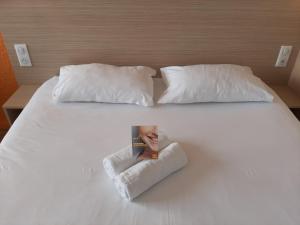 尚特马坎苏迪普瑞米尔经典酒店的一张带两个枕头的白色床和杂志