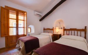 布利亚斯Casa rural Plaza Vieja en Bullas的一间卧室设有两张床和窗户。