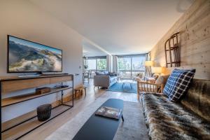 梅杰夫Apartment Cortirion Megeve - by EMERALD STAY的客厅配有沙发和墙上的电视