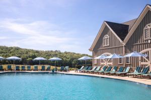 AdairsvilleBarnsley Resort的度假村的游泳池,配有椅子和遮阳伞