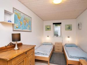 霍伊斯莱乌Holiday home Højslev XVI的一间卧室配有两张床和一张带台灯的桌子