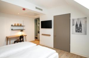 雷根斯堡elaya hotel regensburg city center的酒店客房配有两张床和一张书桌