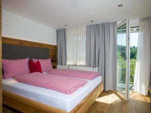 格拉弗瑙卢森布里克旅馆的一间卧室配有红色和白色枕头的床