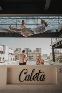 坎昆Caleta Hostel Rooftop & Pool的两个人躺在游泳池里