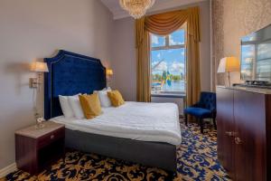 斯德哥尔摩Hotel Gamla Stan, BW Signature Collection的一间卧室配有一张带蓝色床头板的床和窗户