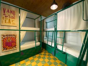 卡利Viajero Hostel Cali & Salsa School的一间设有绿色双层床的房间,并标有Vmo rate la