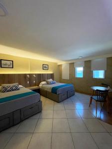 韦拉克鲁斯EXECUTIROOMS VERACRUZ的酒店客房设有两张床和一张桌子。